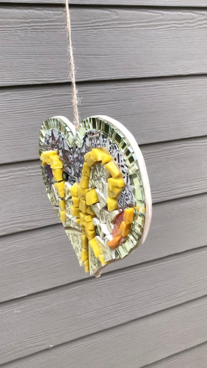 Showing the glimmer of mosaic mirror tiles decorating a heart shape. DIY mosaic heart 